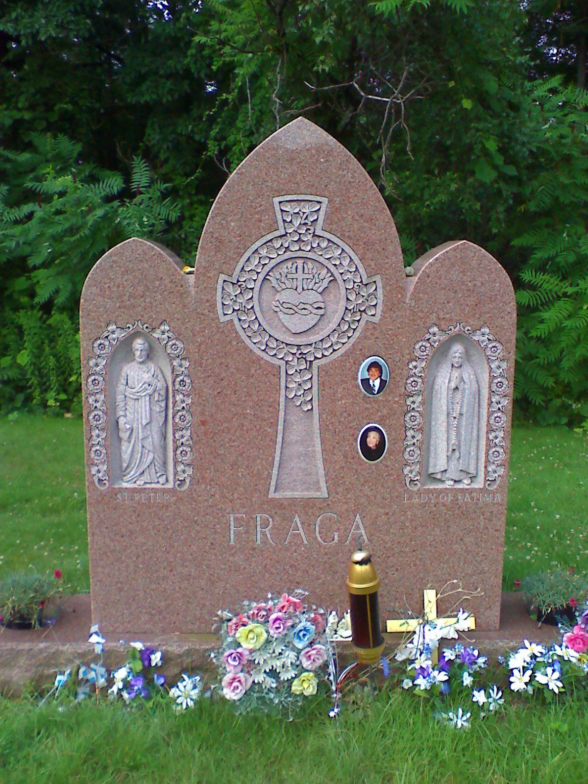 Rose granite three-arch monument with two deeply carved niche figures labelled St Peter and Lady of Fatima, a carved Sacred Heart cross and porcelain photograph ovals, lettered Fraga
