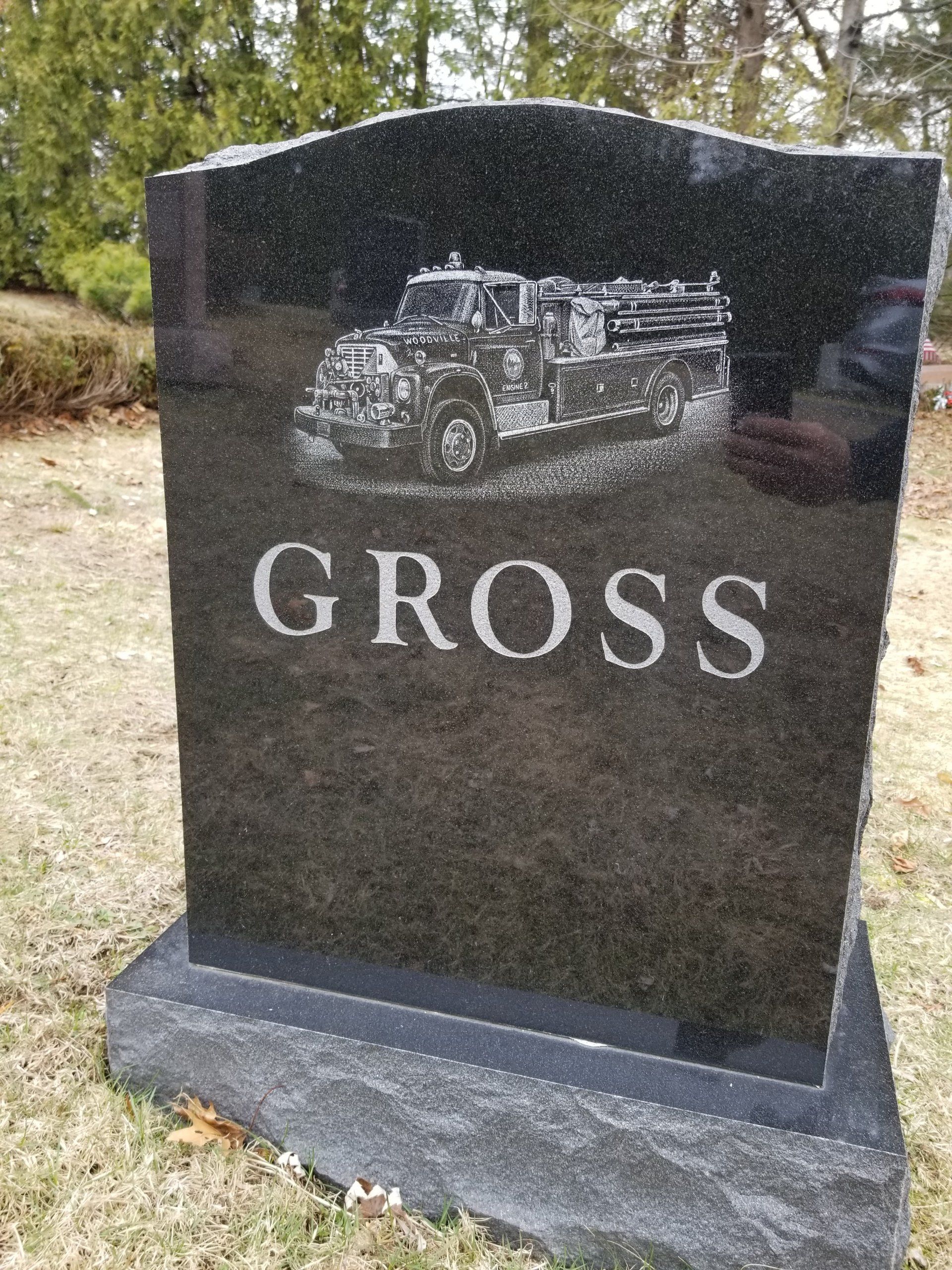 Black granite upright monument with a finely etched fire engine lettered Woodville Engine 2, family name Gross